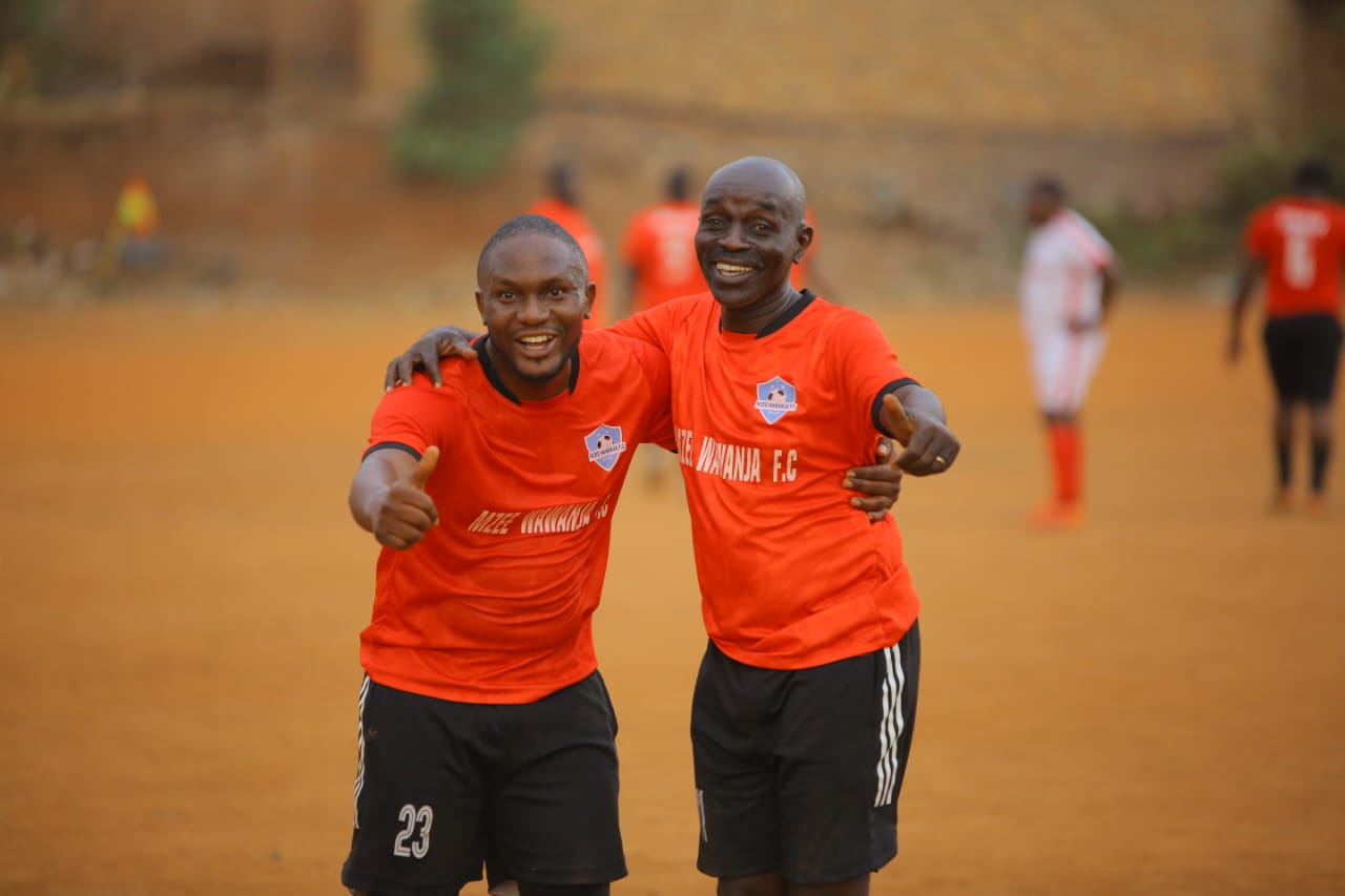 Two Mzee Wawanja players celebrating together on the pitch