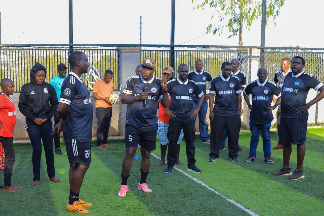 Mzee Wawanja players and supporters listening to a team address